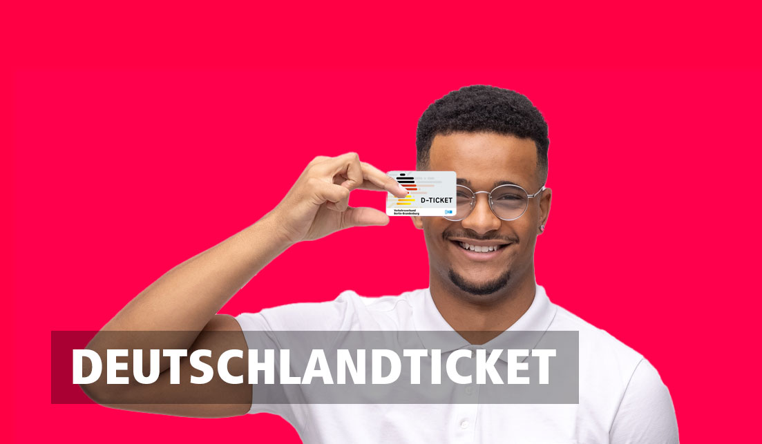 Ein lächelnder Mann hält das Deutschlandticket vor sich hoch.